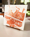 Solid black walnut now playing stand holding a vinyl record sleeve